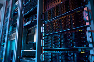 High-performance server rack with supercomputer hardware in a modern big data center, featuring glowing blue and magenta LED indicators on enterprise-grade storage arrays and network switches for AI processing and cloud computing infrastructure.
