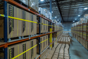 Large warehouse facility housing a massive rental fleet of Airrex portable climate control units on industrial shelving. This organized inventory management system by Temp-Air illustrates how strategic storage and maintenance of portable air conditioners optimize rental fleet ROI and ensure rapid deployment for industrial cooling needs.