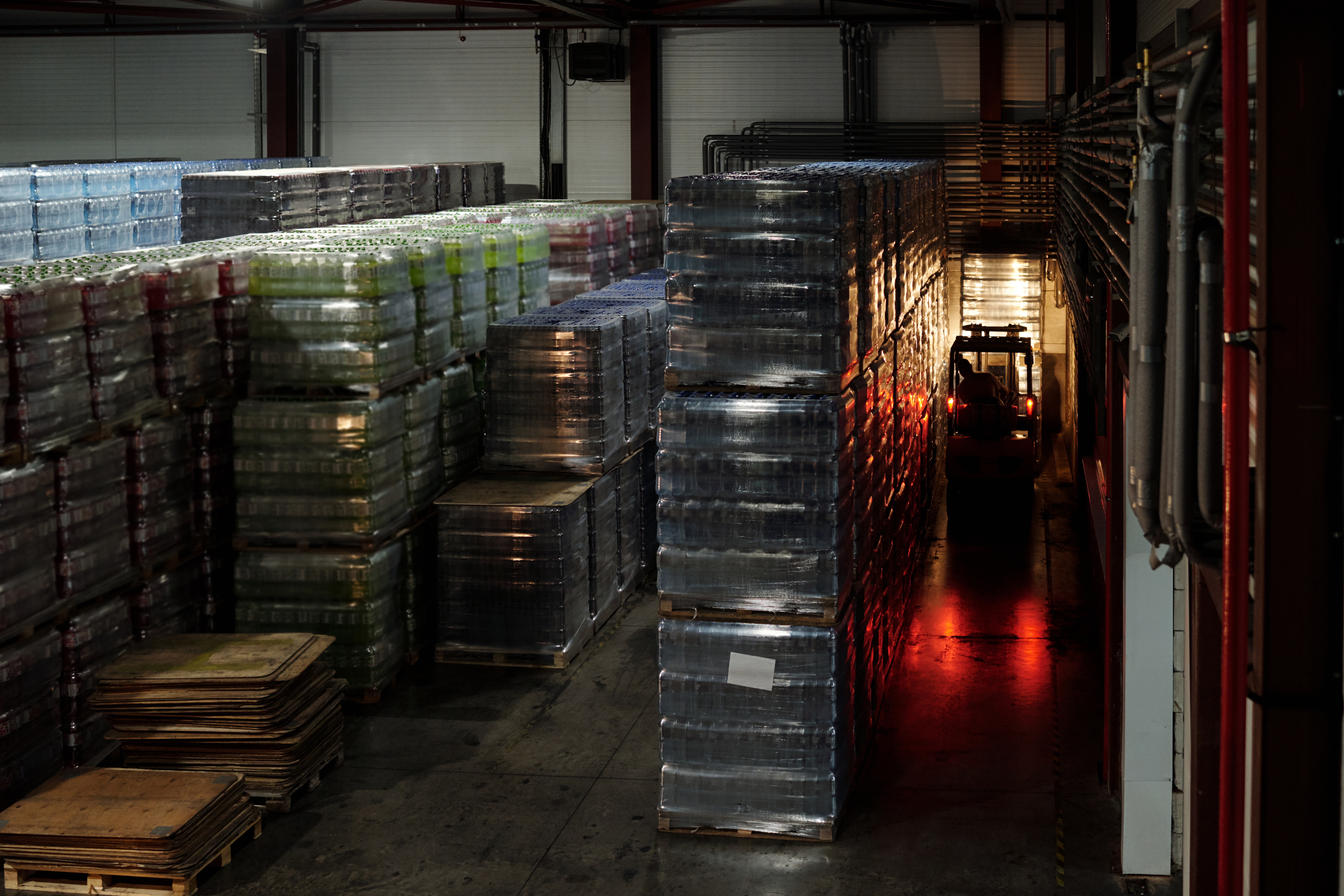 Large industrial warehouse storing pallets of commercial inventory, requiring a portable dehumidifier setup to prevent moisture damage and mold growth.